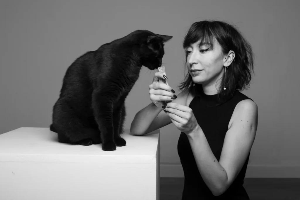 Photographe qui donne à manger à son chat